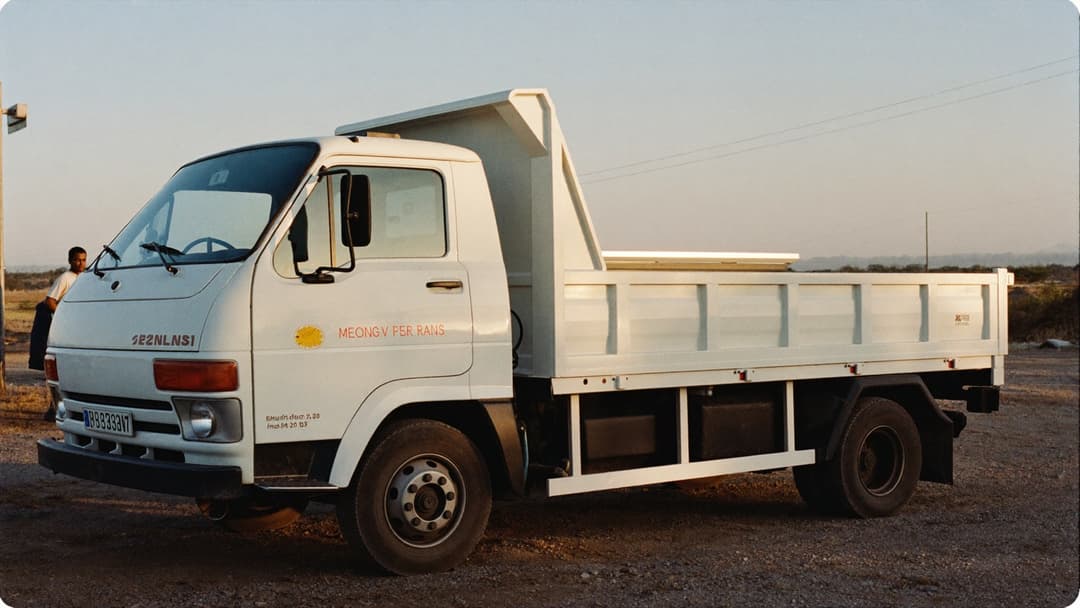Isuzu NPR dump truck loaded with junk parked outside a suburban home
