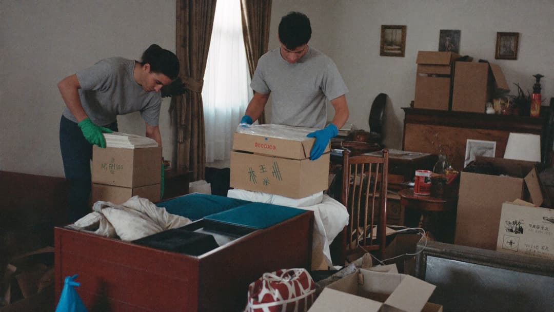 Junk removal crew carrying bags out of a packed hoarder house