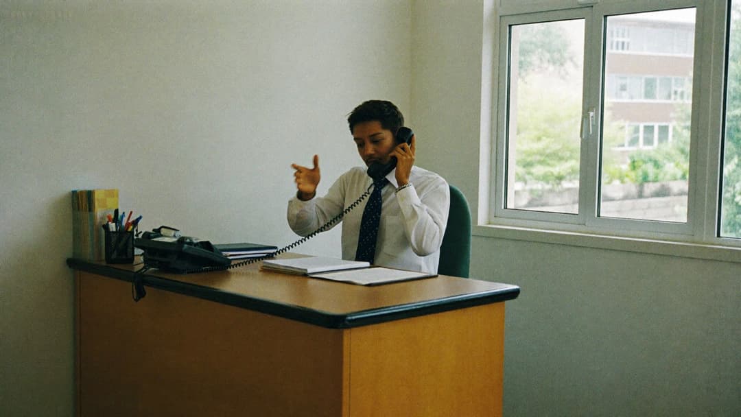 Home service phone operator smiling on a headset call with a booking calendar on screen