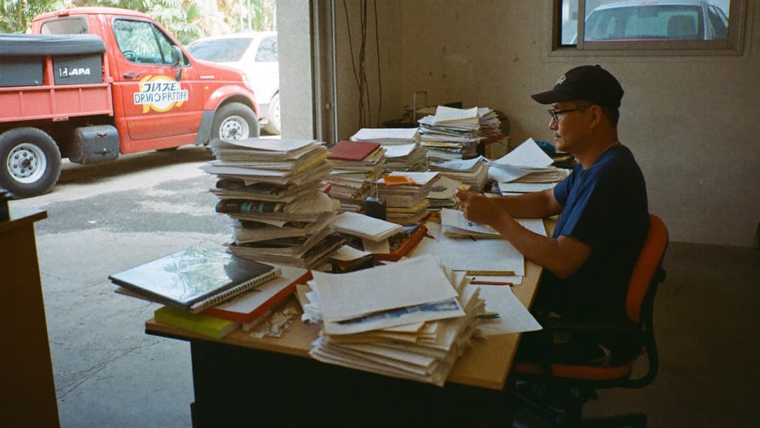 Junk removal owner reviewing a profit and loss spreadsheet next to a loaded dump truck
