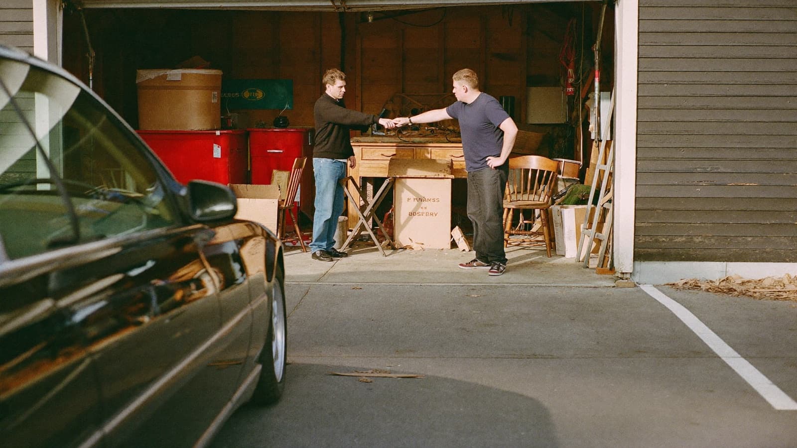 Junk removal crew member reviewing a laminated pricing sheet with a homeowner in a garage