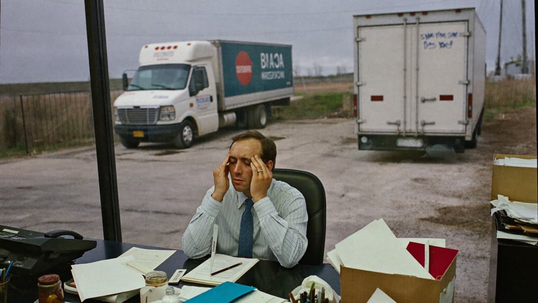 Junk removal owner staring at a fully booked schedule board beside a single truck