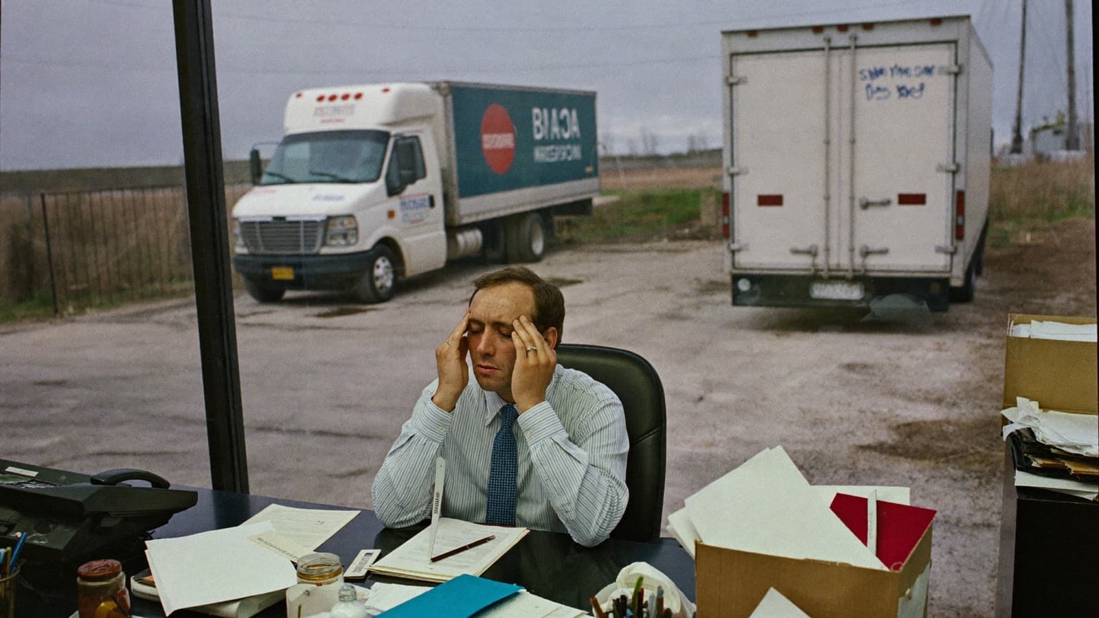 Junk removal owner staring at a fully booked schedule board beside a single truck