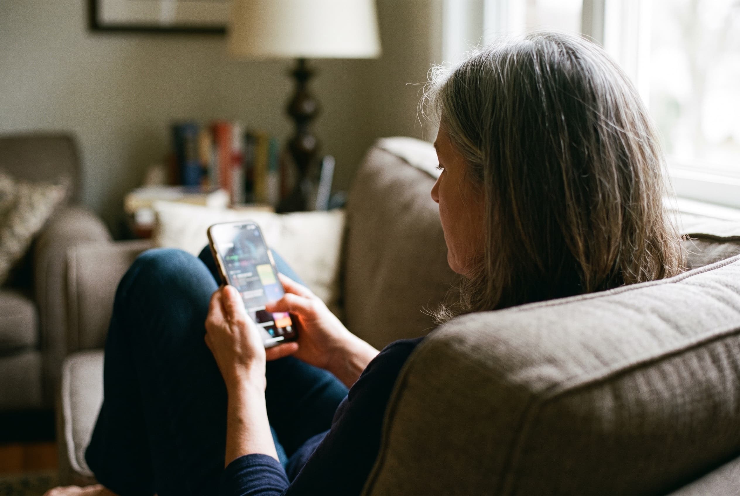A homeowner booking a home service from her couch in the evening