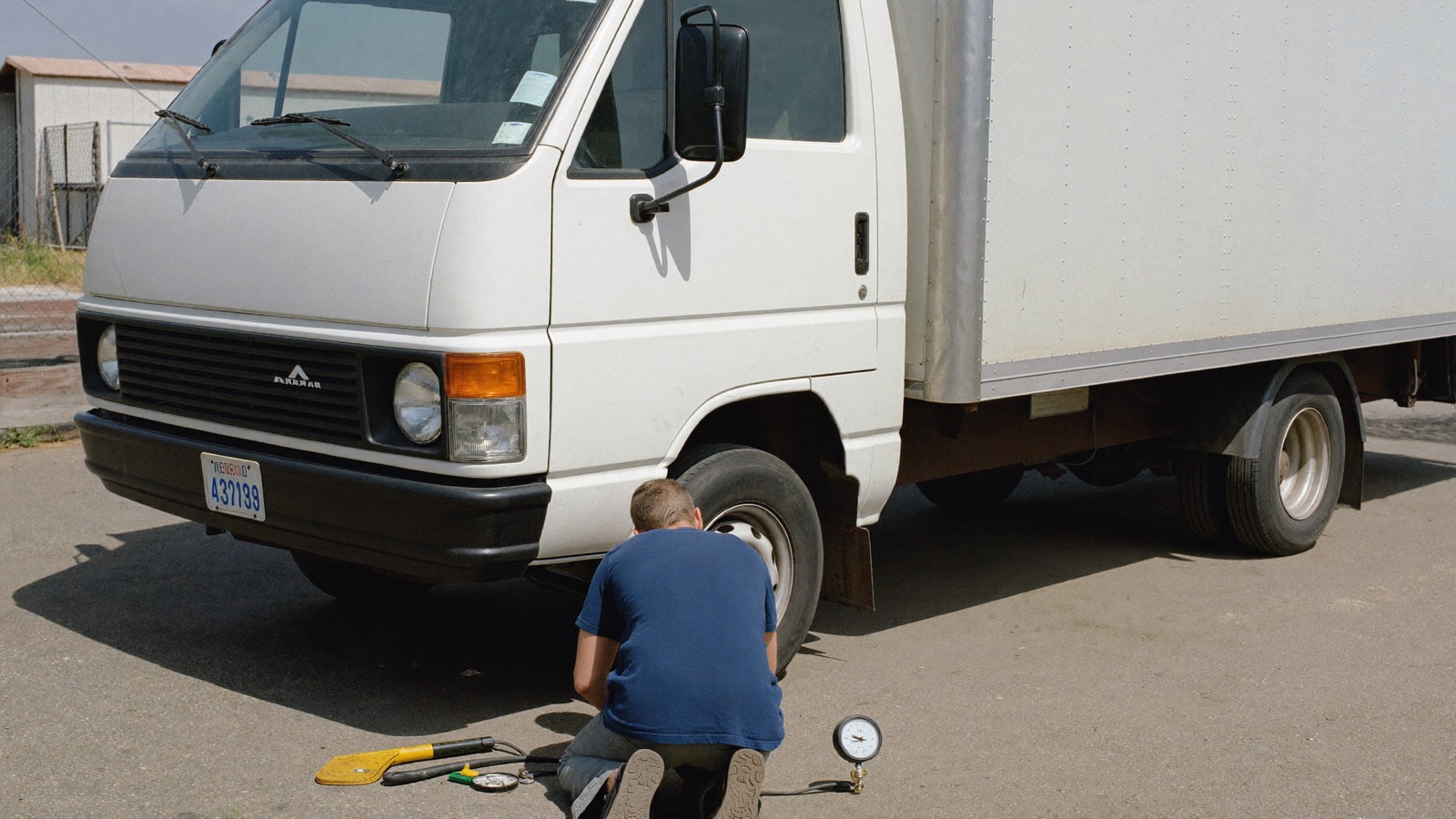 Junk removal crew unloading a box truck by hand at a landfill